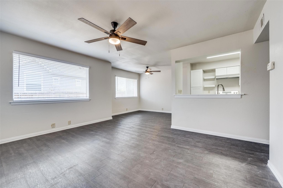 Unfurnished living room with ceiling fan, dark har