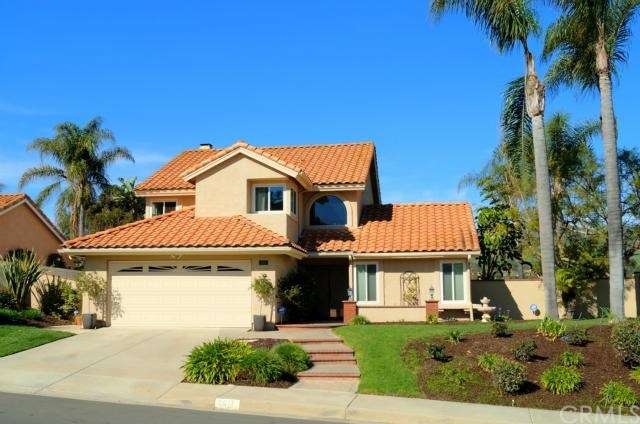 Front of home Lush landscaping with mature palm tr