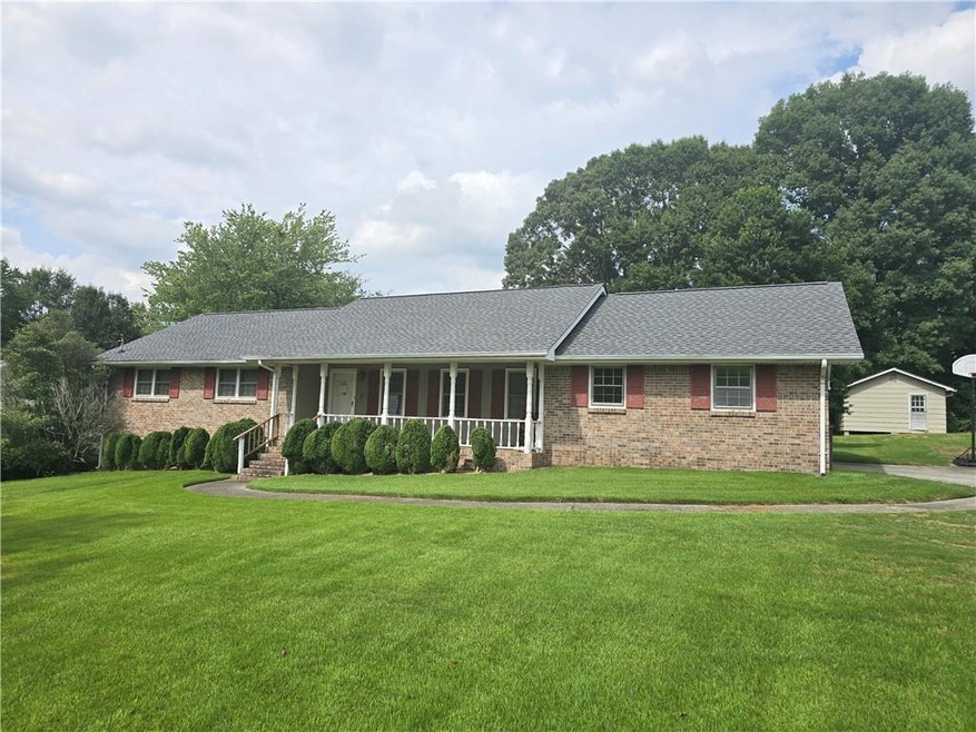 Ranch-style house with a front lawn and covered po