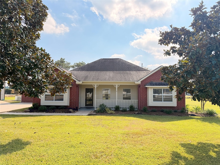 Front entrance with covered porch and magnolia trees.