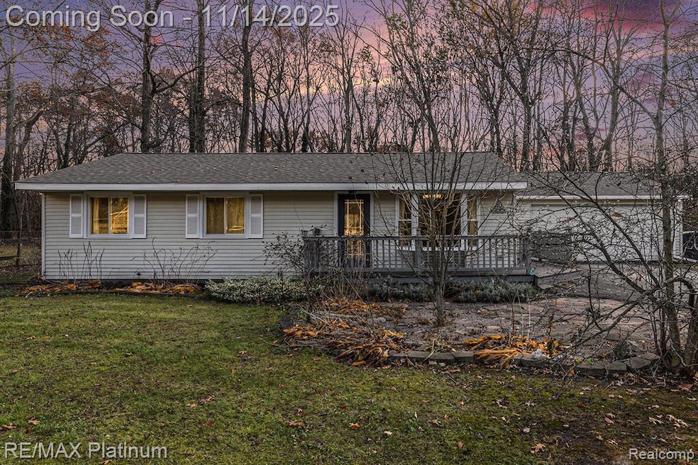 Ranch-style house featuring a front lawn, roof with shingles, and a deck