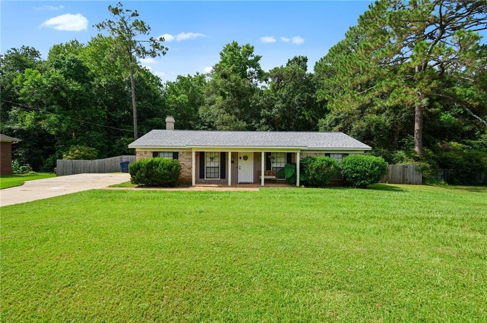 Ranch-style house with a porch, concrete driveway, and a chimney