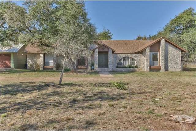 Front of home, set back from the street - circular drive and private courtyard at entry with stone arch.