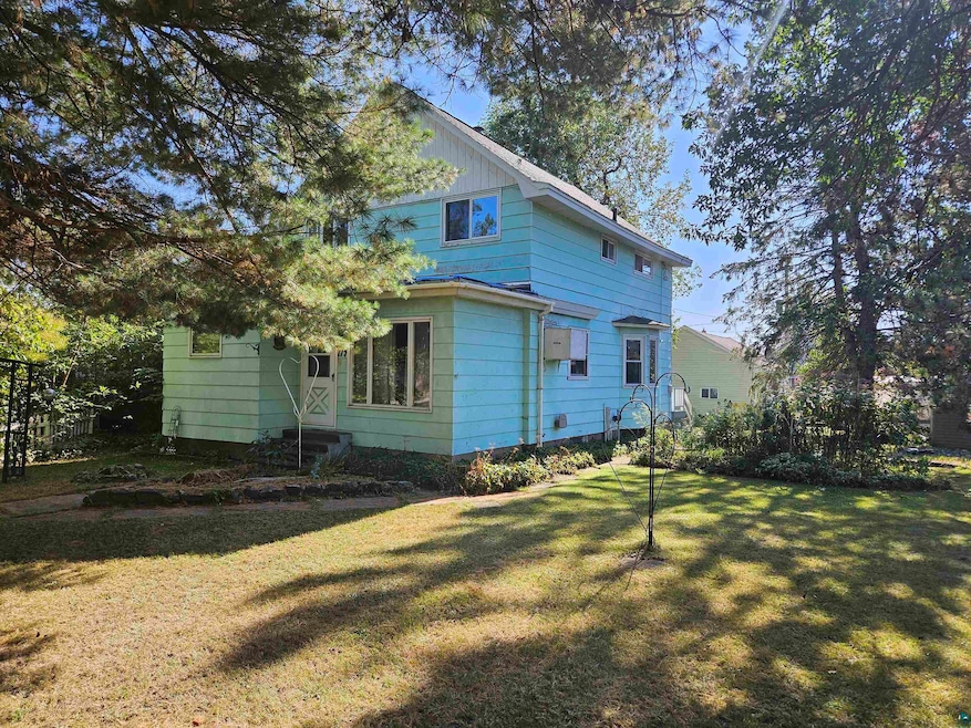 Rear view of property with a lawn