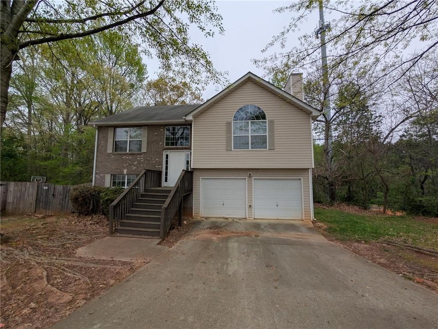Bi-level home featuring a chimney, fence, concrete