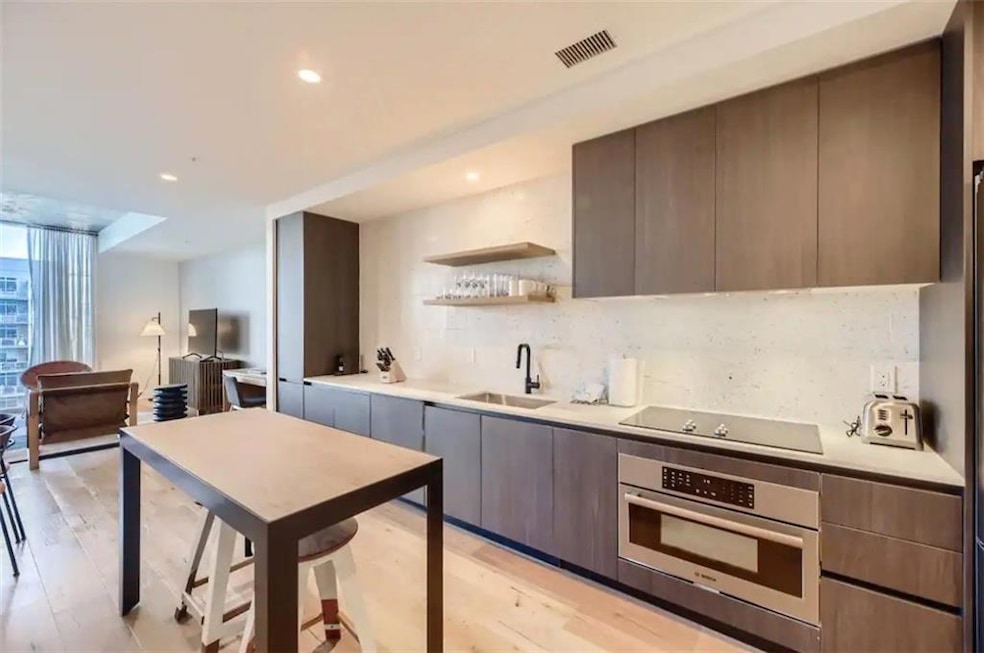 Kitchen with oven, a sink, black electric cooktop