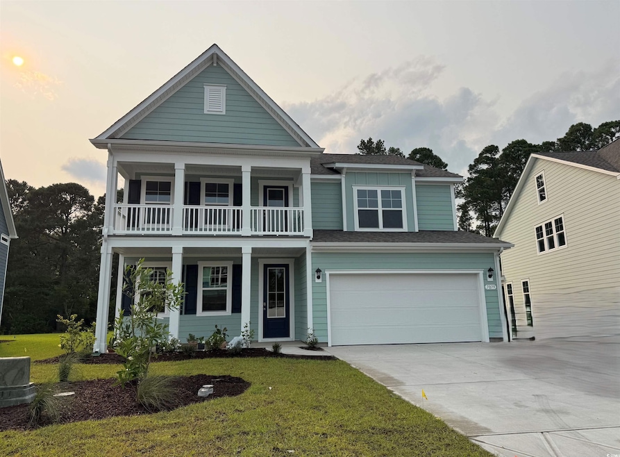 View of front of house with a balcony, driveway, a garage, and a front yard