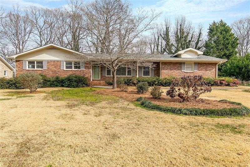 Four sides brick ranch with covered front porch and side entry garage in ideal Austell location.