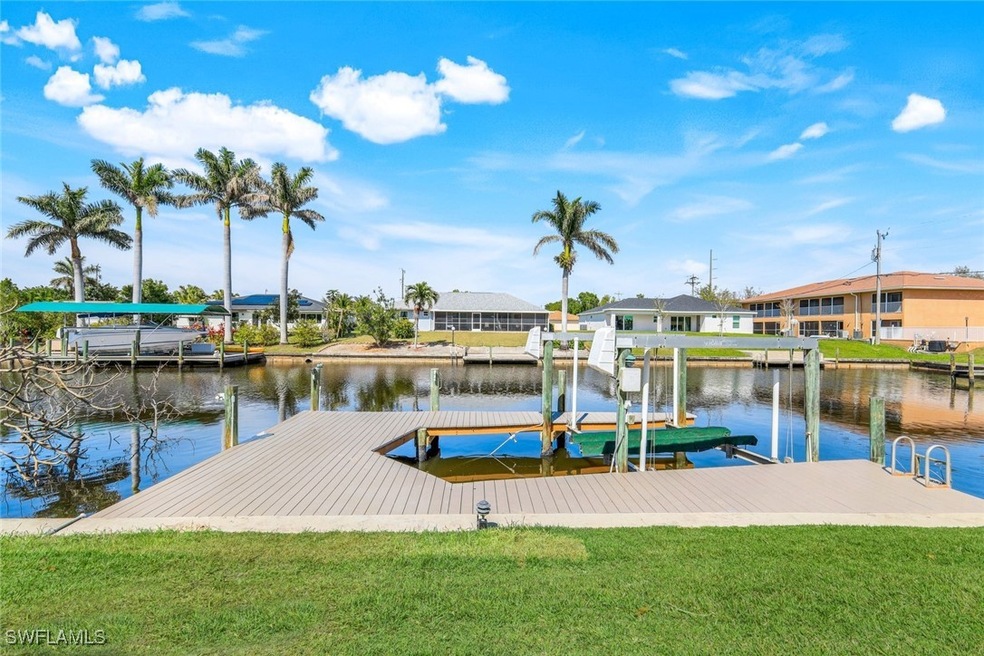 View of dock with a lawn, a water view, boat lift,