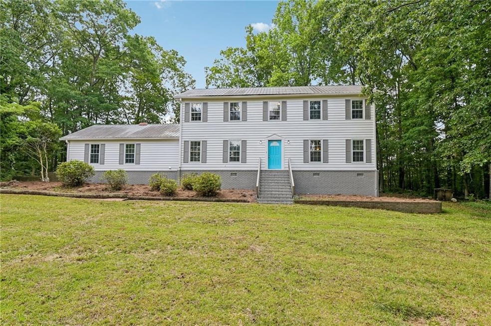 Colonial house with crawl space, a front lawn, and metal roof