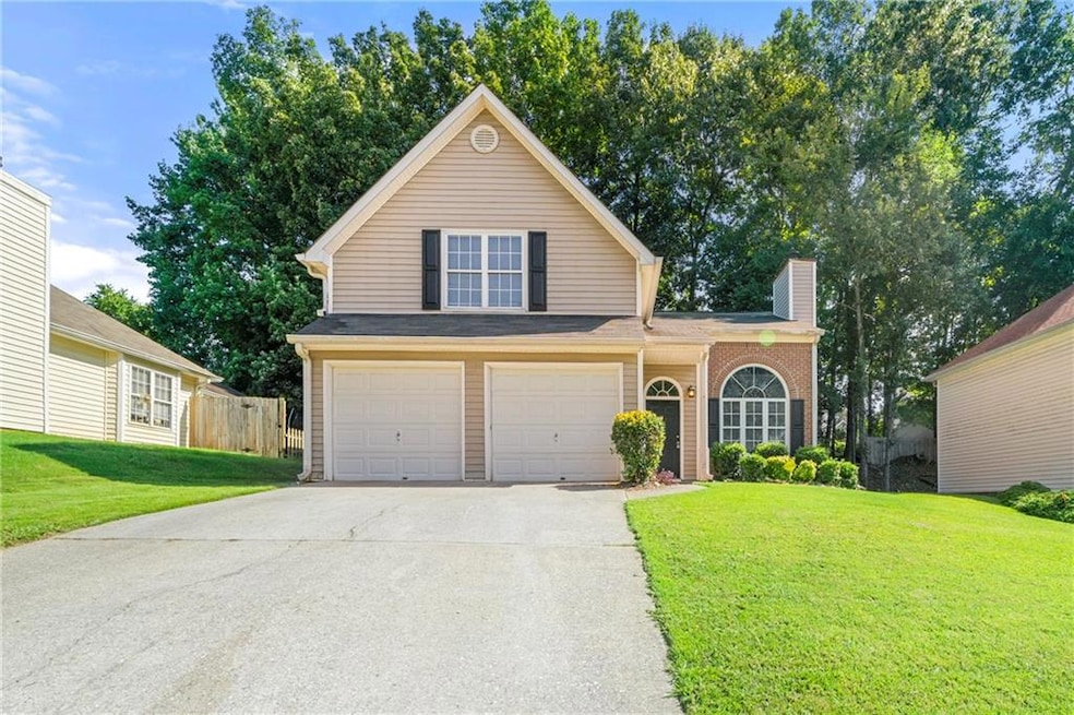 Traditional home featuring concrete driveway, a garage, and a chimney