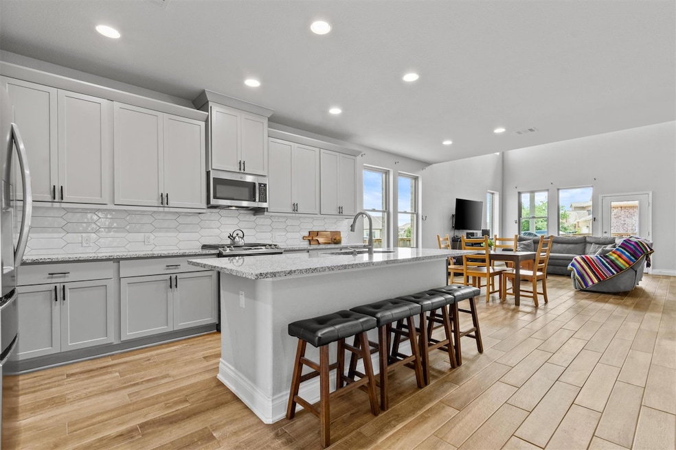 Kitchen with stainless steel microwave, light woo