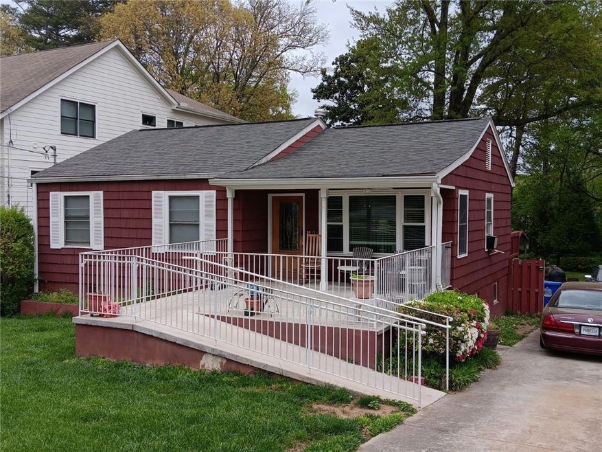 View of front facade with a front lawn and covered