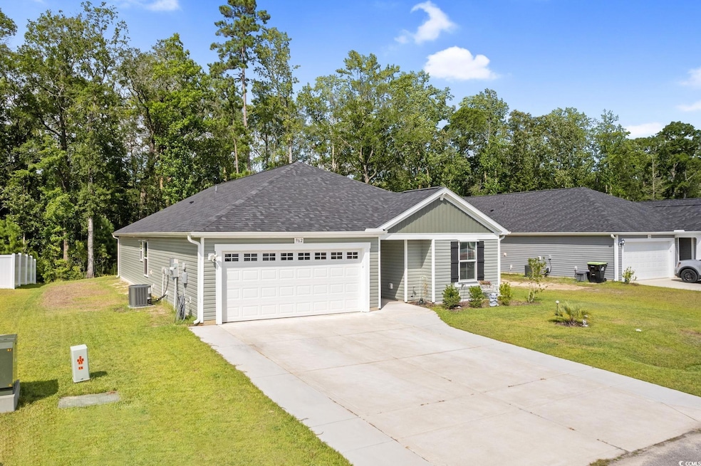 Single story home with a front lawn, driveway, an attached garage, and roof with shingles