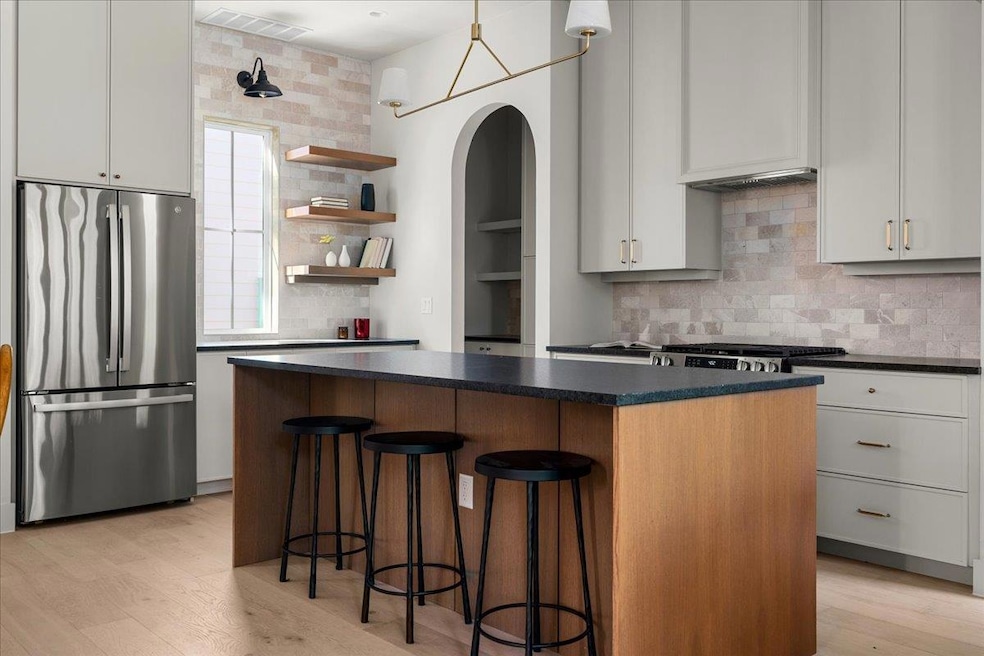 Kitchen featuring freestanding refrigerator, dark