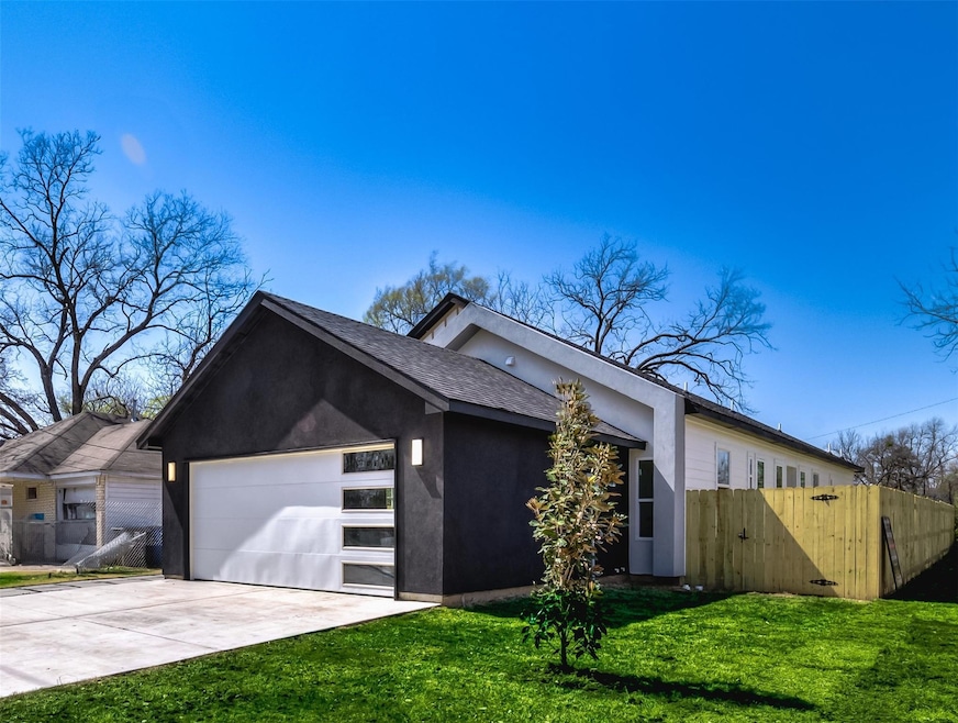 View of front of home featuring driveway, fence, a