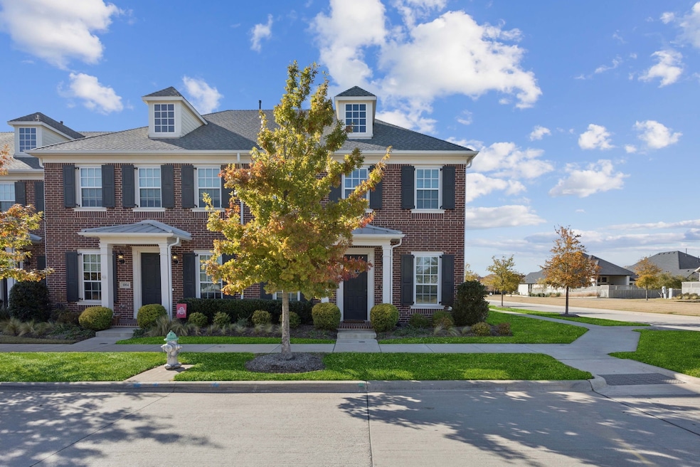 Colonial home with brick siding and a front lawn