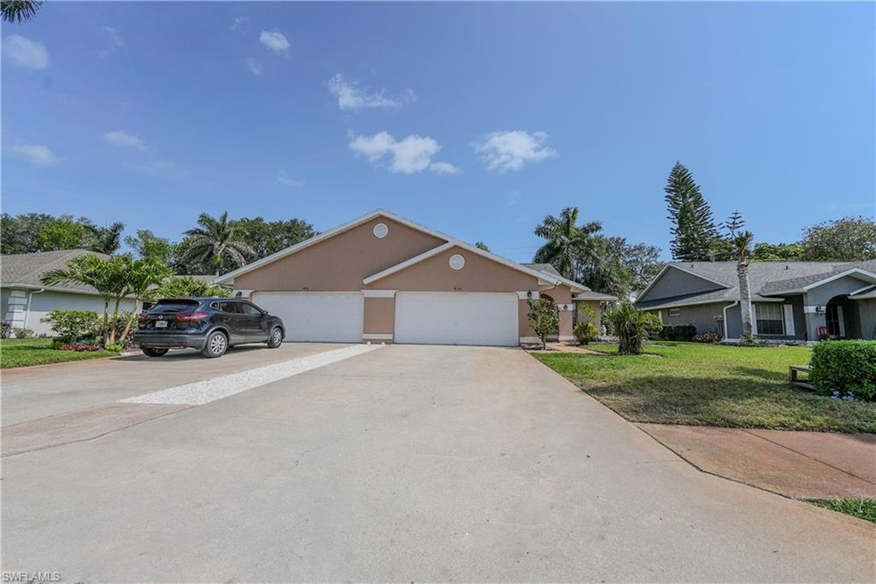 View of front of home featuring a front lawn, driveway, and stucco siding