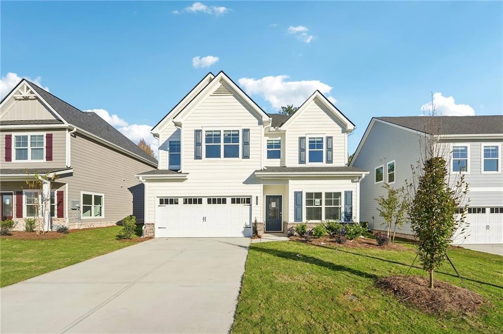 View of front of property with concrete driveway, a garage, and a front yard