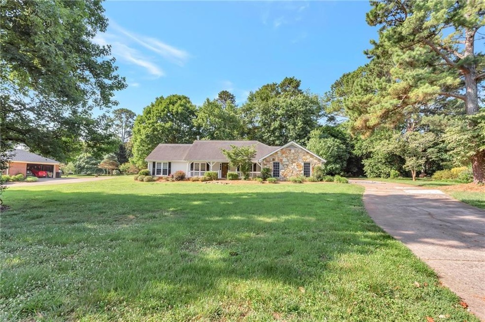 Ranch-style home featuring a front yard, stone sid
