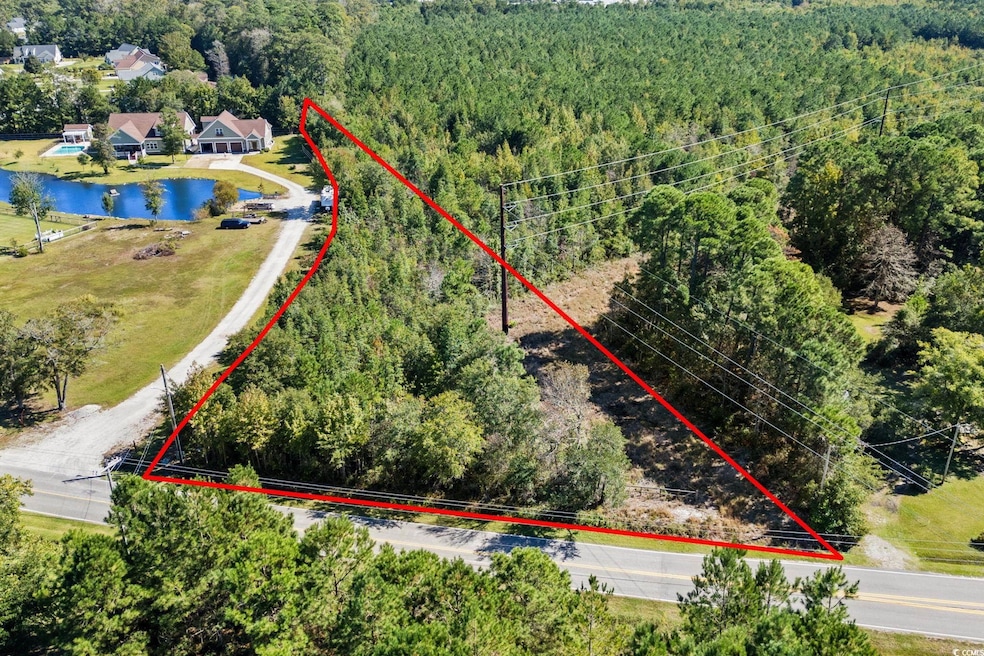 Aerial view of property's location with property parcel outlined and a heavily wooded area