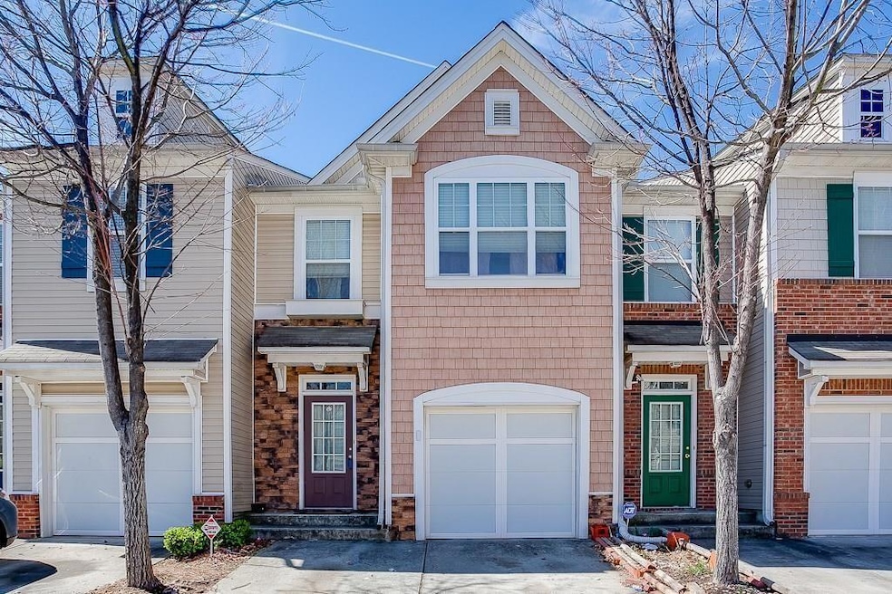 View of property featuring an attached garage and asphalt driveway