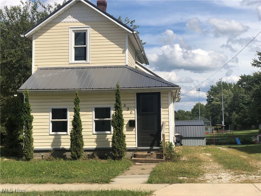 View of front of home with a chimney, a metal roof, a porch, and entry steps
