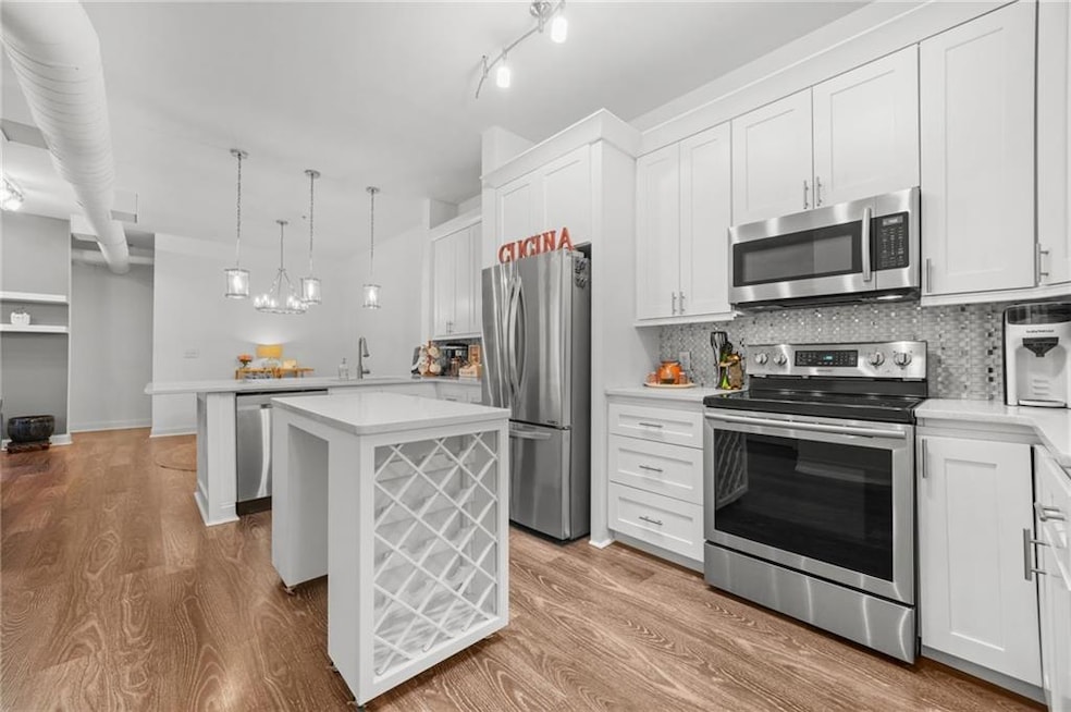Kitchen featuring light wood finished floors, tast