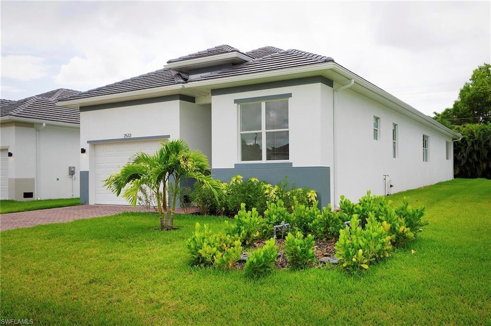 View of front facade with a front lawn, an attached garage, and stucco siding