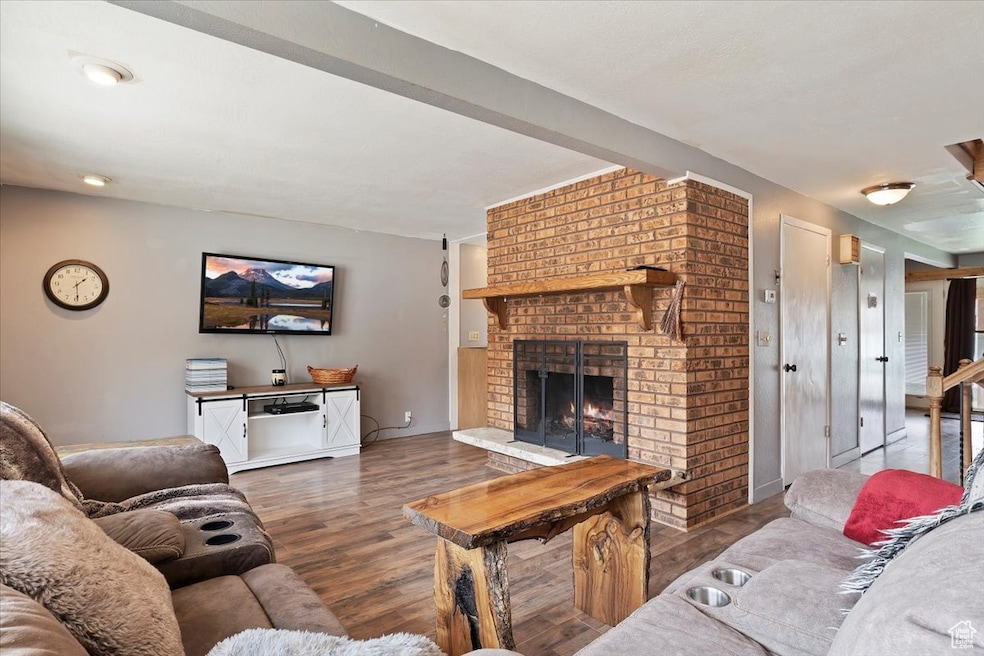 Living room featuring baseboards, a fireplace, and wood finished floors