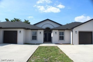 Ranch-style house featuring concrete driveway, a g