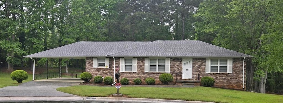 Single story home with brick siding, a carport, dr