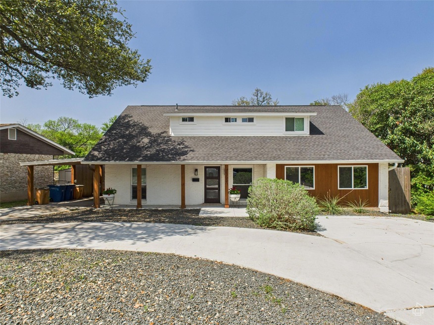 View of front of property featuring driveway, cov