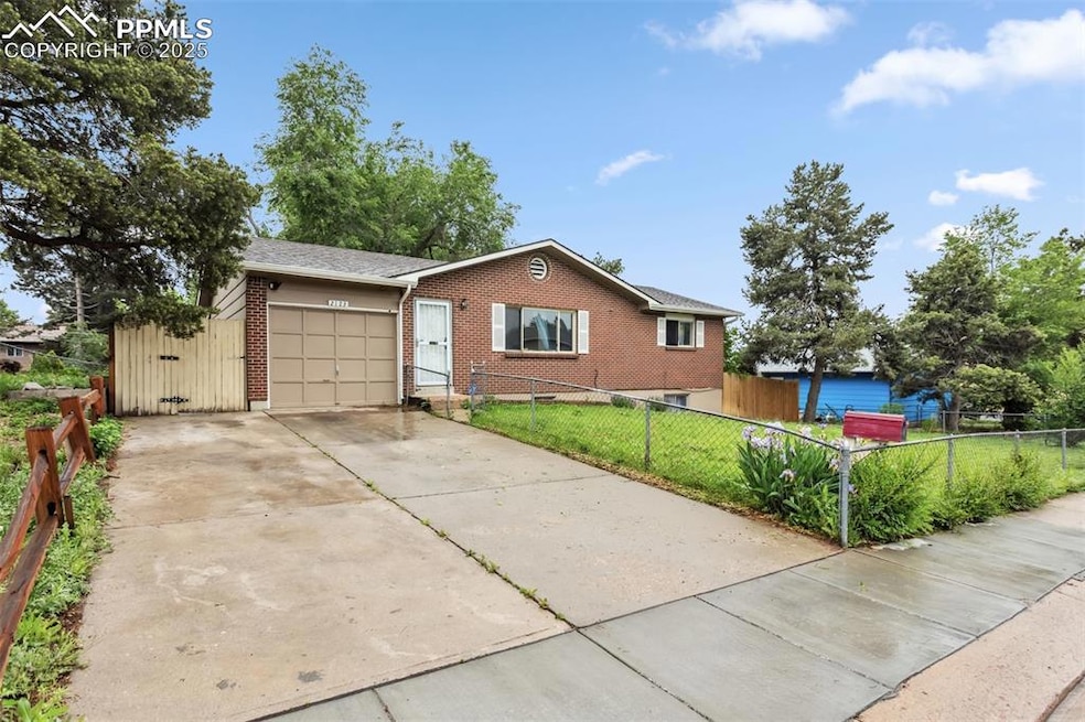 Ranch-style home featuring a garage, brick siding, and concrete driveway