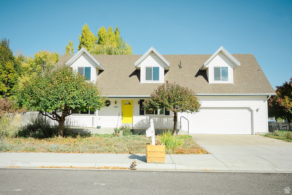 Cape cod-style house with covered porch, concrete driveway, and roof with shingles