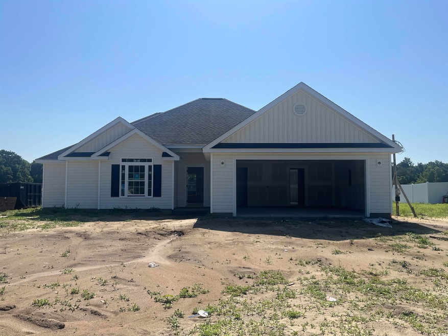 Ranch-style home featuring an attached garage, a shingled roof, and driveway