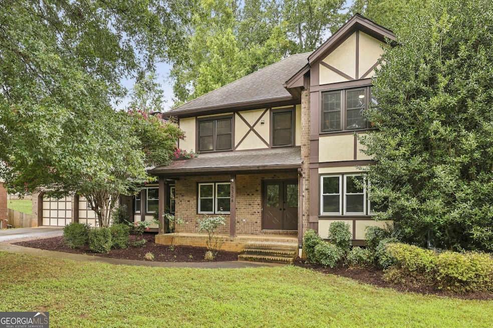 A Tudor Revival Southern Charmer with Timeless Curb Appeal and Inviting Outdoor Spaces!