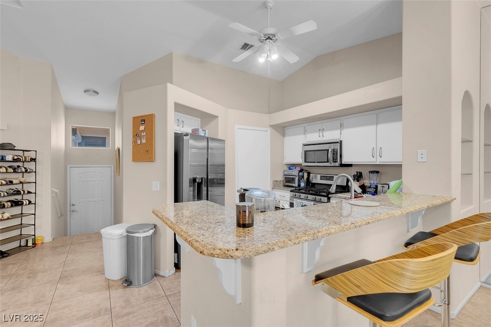 Kitchen featuring ceiling fan, a breakfast bar, a