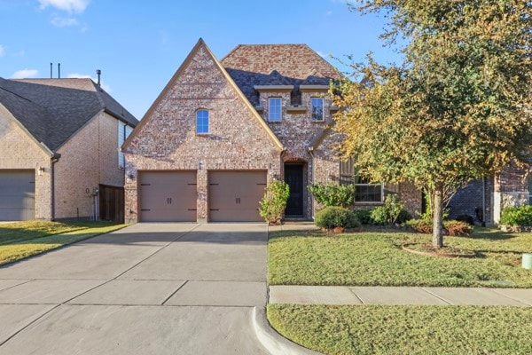 View of front facade featuring concrete driveway, a front yard, brick siding, and a garage