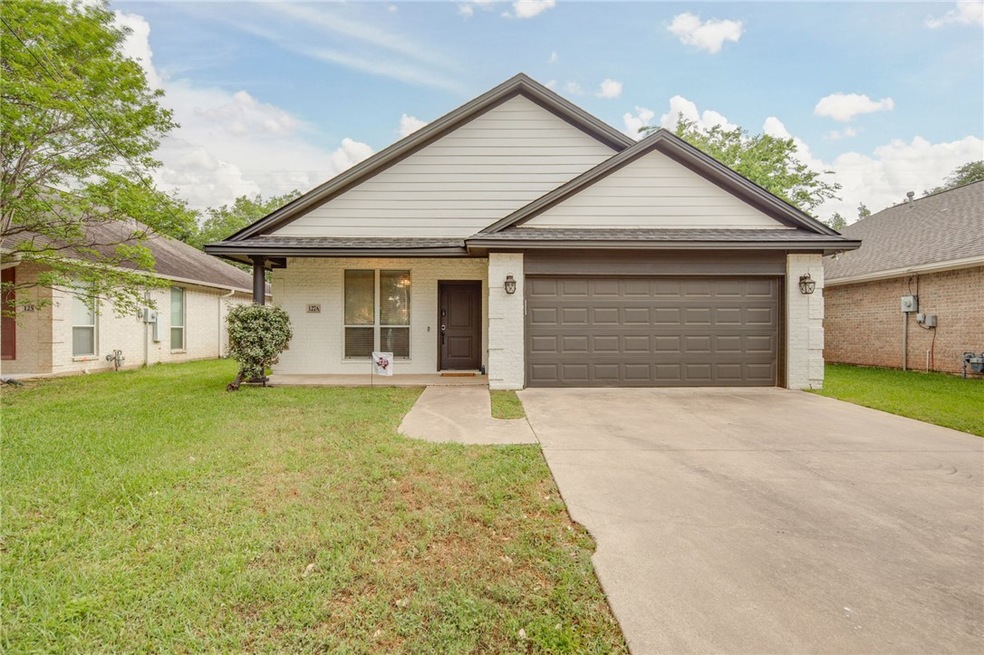 View of front facade with driveway, covered porch,