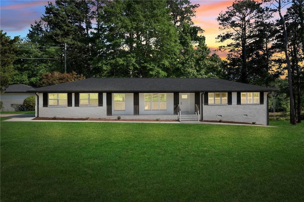 Ranch-style home with a lawn and brick siding