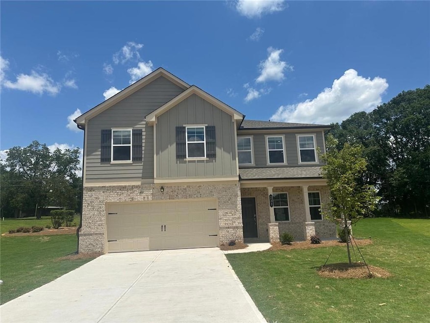 Craftsman-style house featuring a garage, concrete driveway, a front lawn, and board and batten siding