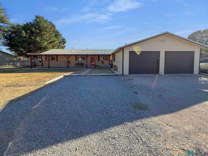 View of front facade with a metal roof, driveway, a porch, and an attached garage