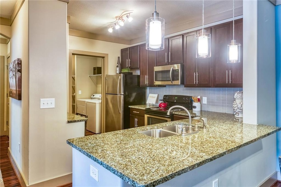 Kitchen featuring hanging light fixtures, applianc