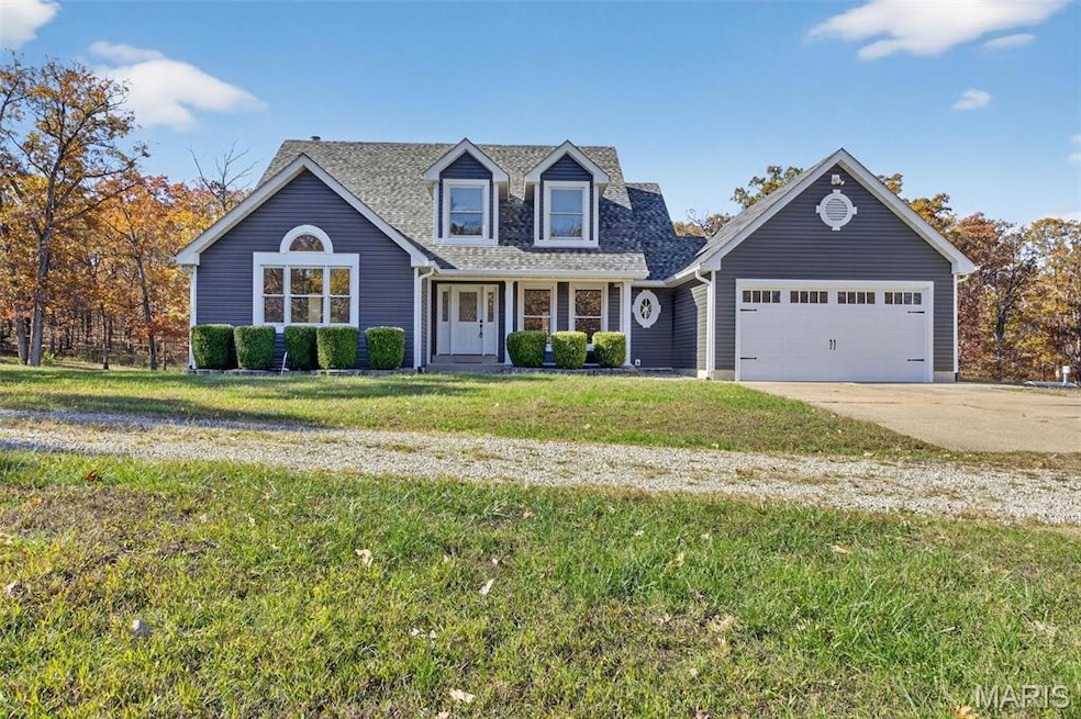 Cape cod home featuring covered porch, concrete driveway, a front lawn, a shingled roof, and an attached garage