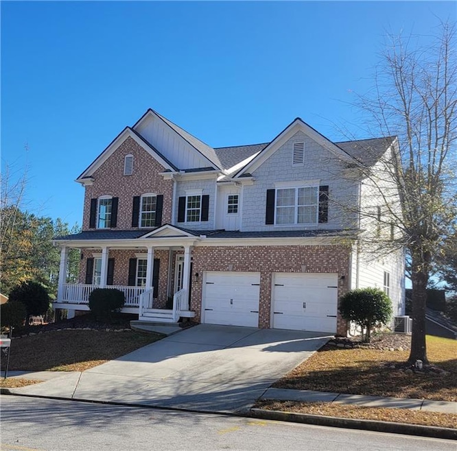 View of front facade featuring a porch, a garage, 