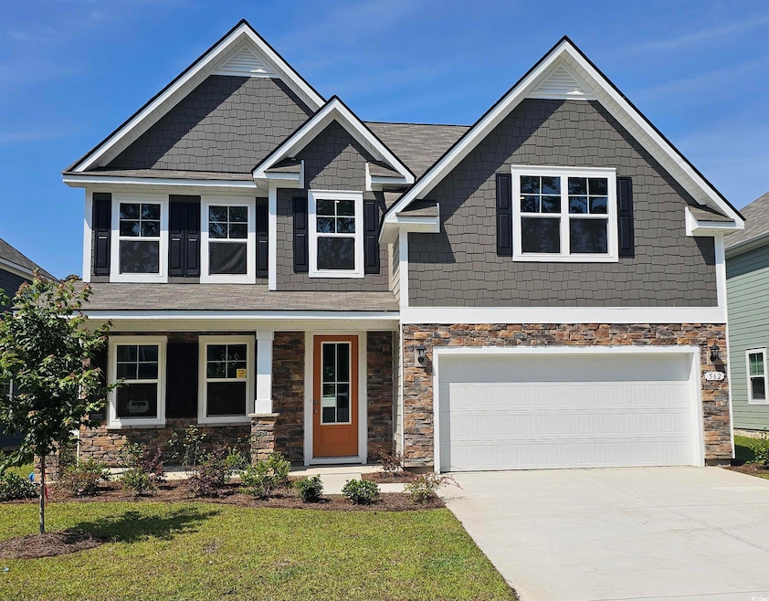 Craftsman inspired home featuring concrete driveway, stone siding, a front lawn, and an attached garage