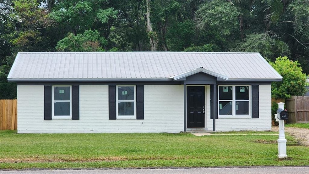 Single story home featuring brick siding and a metal roof