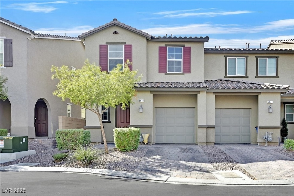 Mediterranean / spanish home featuring a garage, decorative driveway, and stucco siding