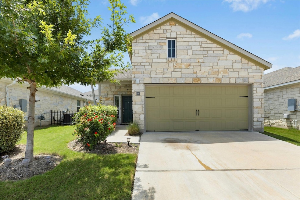 View of front of house with stone siding and concrete driveway